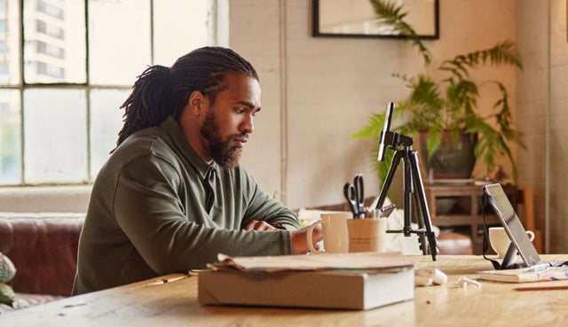 photo of a person working on a smart phone at a desk